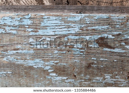 Old wooden background with remains of pieces of scraps of old paint on wood. Texture of an old tree, board with paint, vintage background peeling paint. old blue board with cracked paint, vintage
