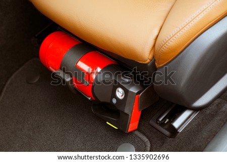 Small red fire extinguisher in the car to prevent emergencies. Royalty-Free Stock Photo #1335902696