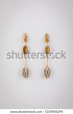 Womens golden earrings  with light brown stones on chain, isolated on a white background. 