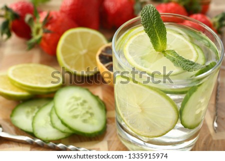 Lime with cucumber punch home made cocktail closeup on wood background