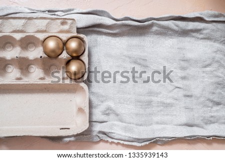 golden eggs on a gray linen napkin. concept of wealth. easter concept. copy space