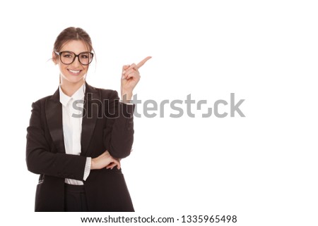 Closeup portrait of a beautiful Caucasian business woman presenting the copyspace, girl indicating wit index finger the wall wearing formal black suit, shirt cutout isolated on a pure white background