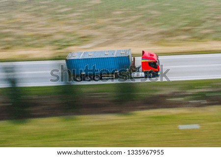 Panning Truck red and blue container cargo in highway delivery your goods buy online on e-commerce. View by Drone - Shipping on the road.