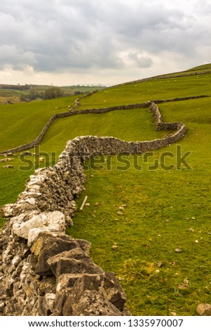 Dry stone walls snake their way into the distant fields on the Yorkshire Moors near Malham, North Yorkshire
