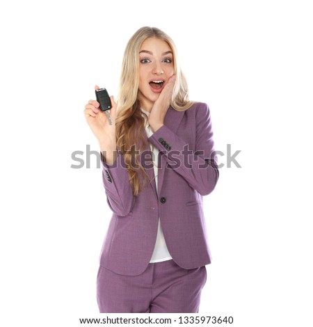 Happy young businesswoman with car key on white background. Getting driving license