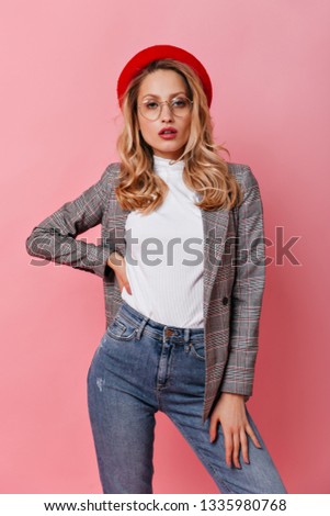 Portrait of woman with wavy blond hair posing in stylish casual outfit and French beret