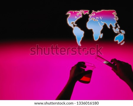 hands holding beaker and test tube with map of the world