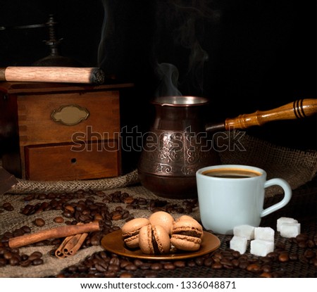 Coffee grinder with a cup, coffee beans and dessert. Coffee still life on the background of sack, kitchen sack