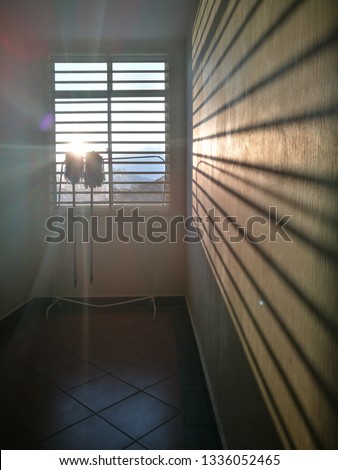 Light and shadow of cleaning tools hanging near window