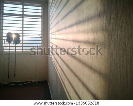 Mops hanging near window during morning sunrise. Selectively focused