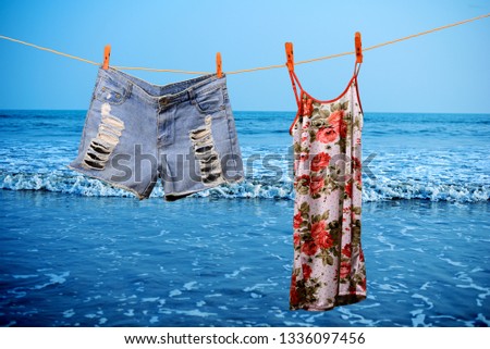 Woman casual clothing are hanging in a rope in a sea beach