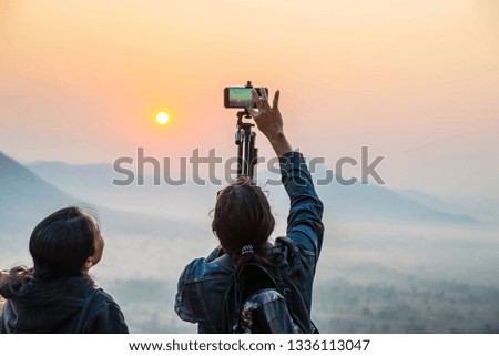 People using smart phones to take pictures of the sunrise in the morning.