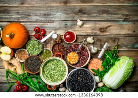 Healthy food. Healthy assortment of vegetables and fruits with legumes. On a wooden background.