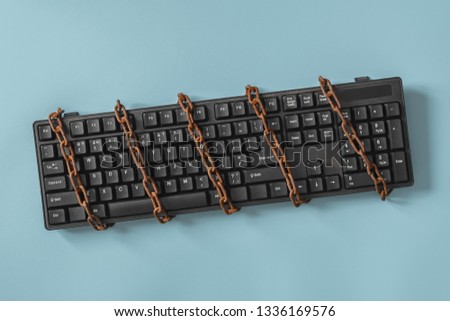 Black keyboard with a coiled chain. Idea and concept for the topic of censorship or freedom of the press. Royalty-Free Stock Photo #1336169576