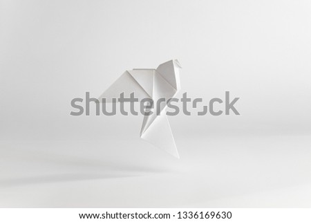 Origami dove made of white paper on white plain background. Minimal concept. Royalty-Free Stock Photo #1336169630