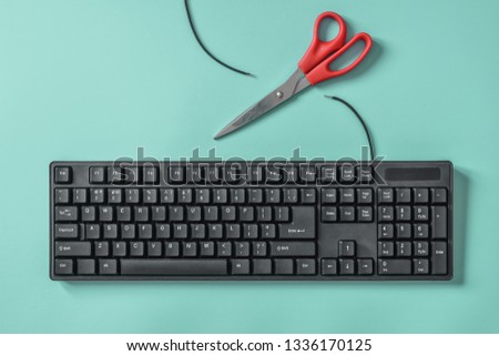 Red scissors and a black keyboard with a cut wire. Idea and concept for the topic of censorship or freedom of the press. Royalty-Free Stock Photo #1336170125
