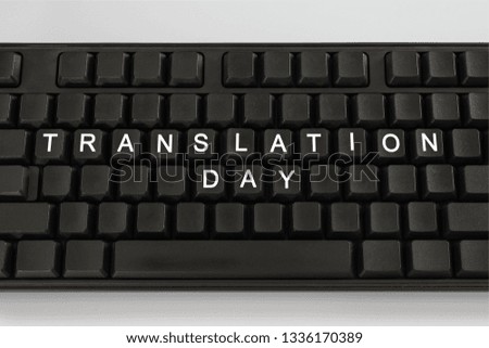 Black keyboard on white light background. The inscription on the buttons - Translation Day. Minimal concept.