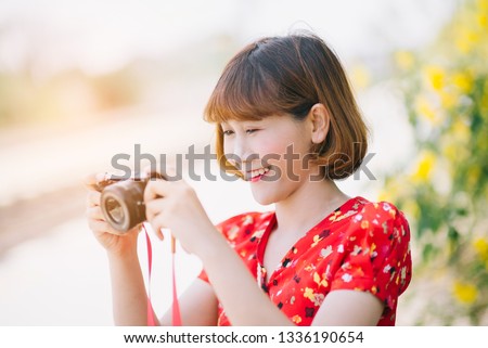 Beautiful young woman taking photos with her camera.