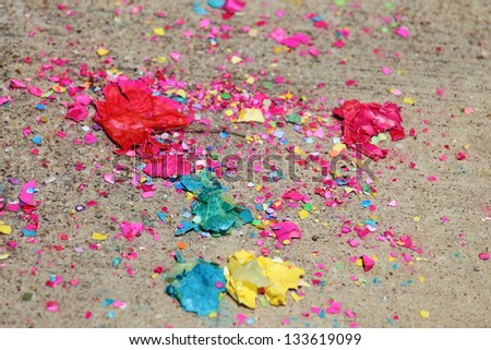 Close up view of broken confetti eggs and confetti spread out over the floor