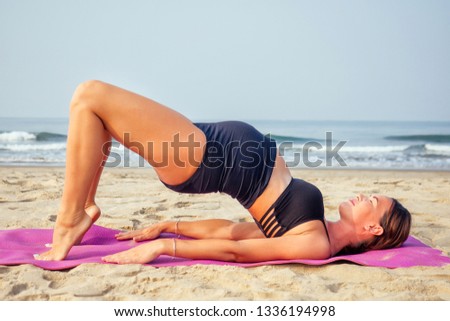 Pregnant woman on the beach doing yoga