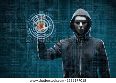 Computer hacker in mask and hoodie over abstract binary background. Obscured dark face. Data thief, internet fraud, darknet and cyber security.