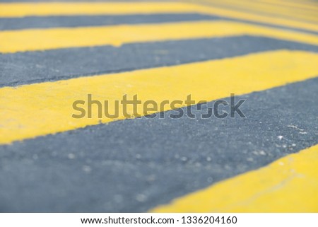 Yellow and Black diagonal line on the concrete street/road surface. abstract background texture
