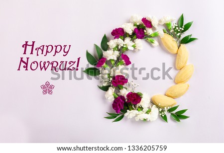 Novruz wreath made of traditional Azerbaijan pastry shekerbura and beautiful white, violet flowers for spring celebration, light lilac background, top view. Translation: "Happy Nowruz" greeting card