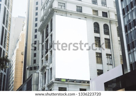 Empty white poster on city building. Public ad and commercial concept. Mock up 