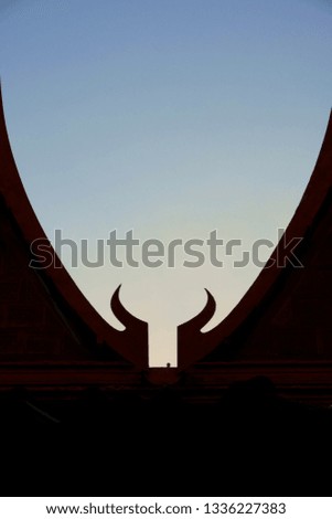The gable roof of the house in the silhouette in the blue sky