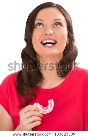 Closeup portrait of charming woman wearing orthodontic braces holding silicone trainer and smiling