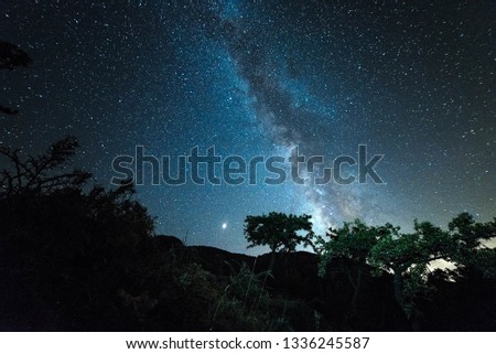 a cold night sheltered in a cave with a background of a castle that can be seen milky way