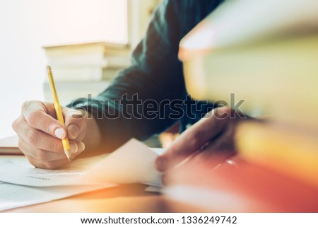 high school,college,university student writing in class room or library at work space with book stack for knowledge prepare exams scholarship study abroad.research world international education learn
