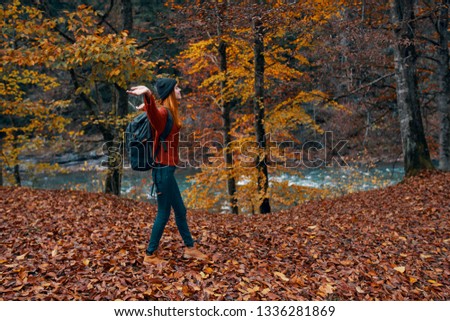  Traveler resting in the forest with a backpack on her back autumn mountain river tourism                              