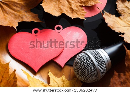 Song for lovers. Nostalgic songs, fallen leaves and melancholy. Concept with vinyl records, microphone and hearts. Royalty-Free Stock Photo #1336282499