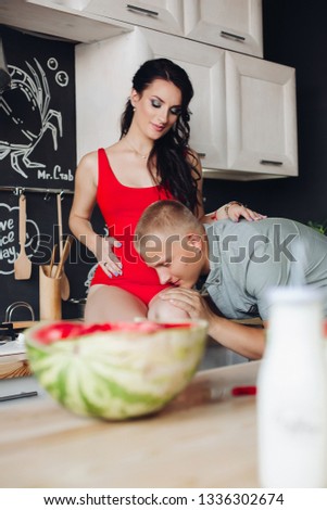 Loving husband communicating with baby inside his wife.