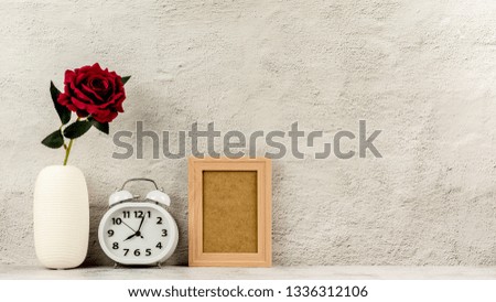 Classic wooden photo frame with alarm clock and a red rose. - blank space for message and advertising background.