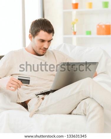 picture of young man with laptop and credit card at home