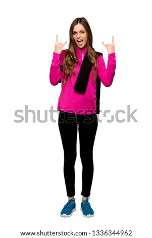 Full-length shot of Young sport woman making rock gesture over isolated white background