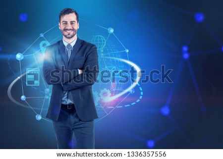 Portrait of smiling businessman wearing black suit standing with crossed arms over dark blue background with internet icons. Concept of hi tech. Toned image mock up
