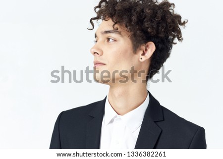 handsome guy in a jacket and white shirt, curly hair and earring in the ear                              