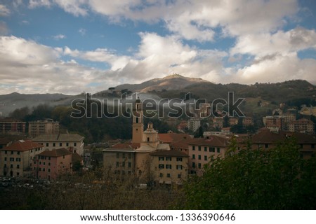Genoa, Italy. View of the day city with old architecture on a background of mountains blue sky and clouds