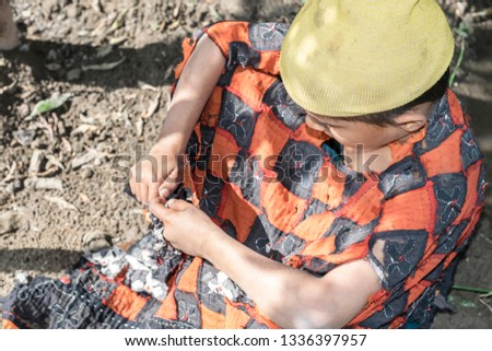 an isolated tribal boy is wearing torn wild clothes with sad expression 