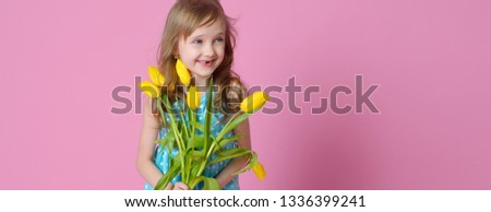 Banner beautiful blonde baby with a bouquet of yellow tulips on a pink background. Concept of holidays, fashion and beauty. happy Easter.