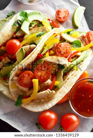 Tasty healthy tacos with chicken meat and fresh vegetables.