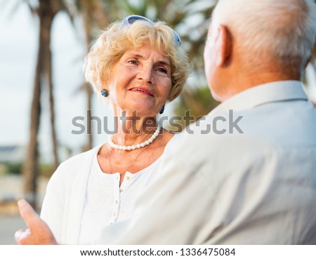 Portrait of old happy male and female talking on the nature 