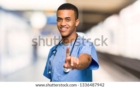Surgeon doctor man showing and lifting a finger in a hospital