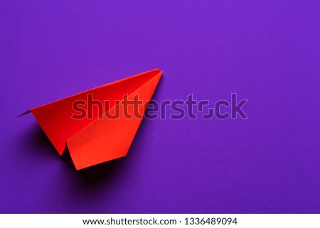 white paper airplane on a purple background