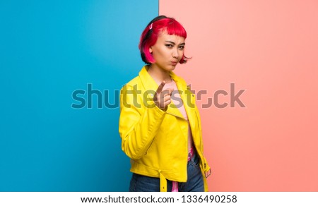 Young woman with yellow jacket frustrated and pointing to the front