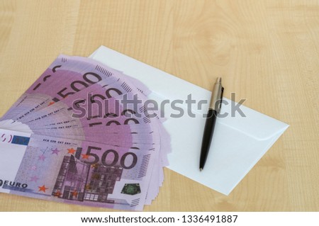 pen white envelope and cash on Desk