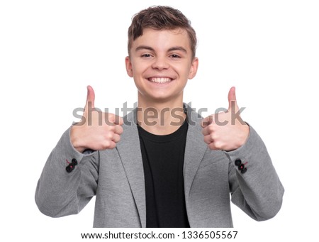 Handsome Teen Boy in suit making Thumbs up Gesture. Portrait of caucasian Smiling Teenager isolated on white background. Happy child looking at camera.